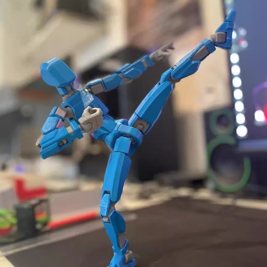 Orange 3D-printad robotfigur i pose